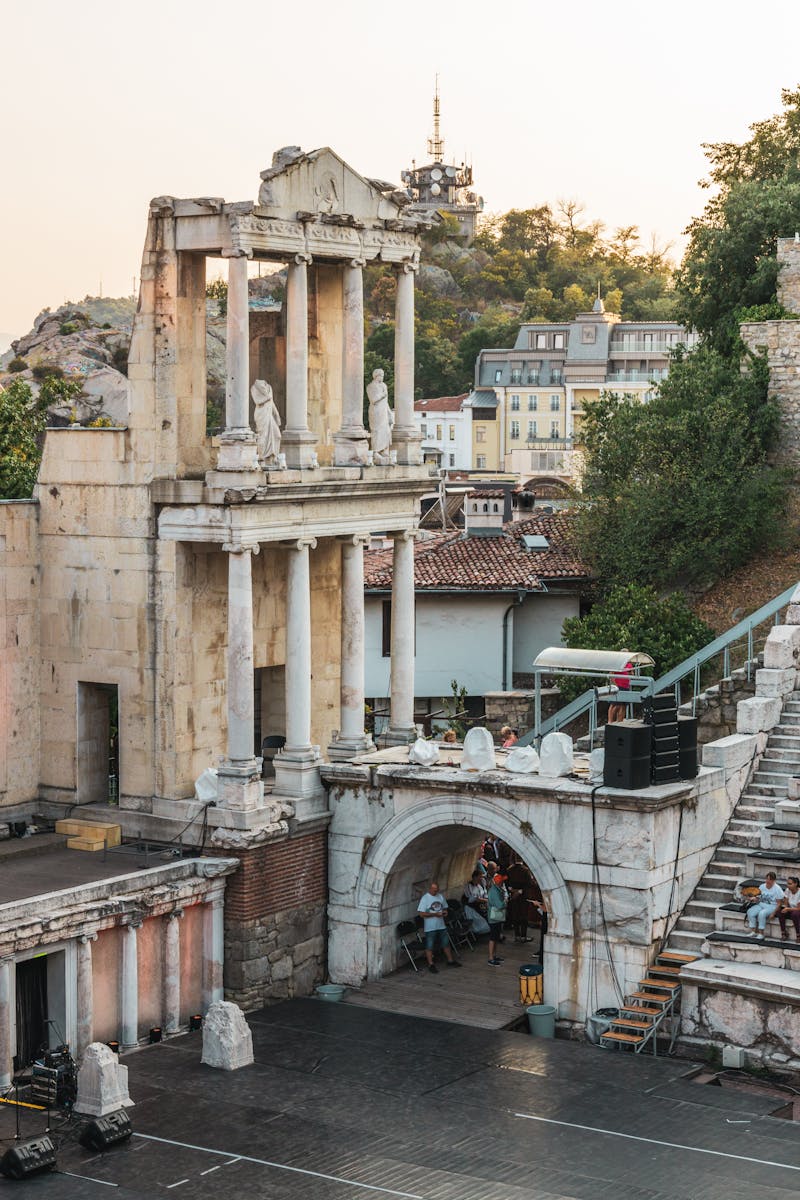 Explore the ancient Roman Theatre of Plovdiv, Bulgaria, captured at sunset, amidst scenic ruins and cityscape.